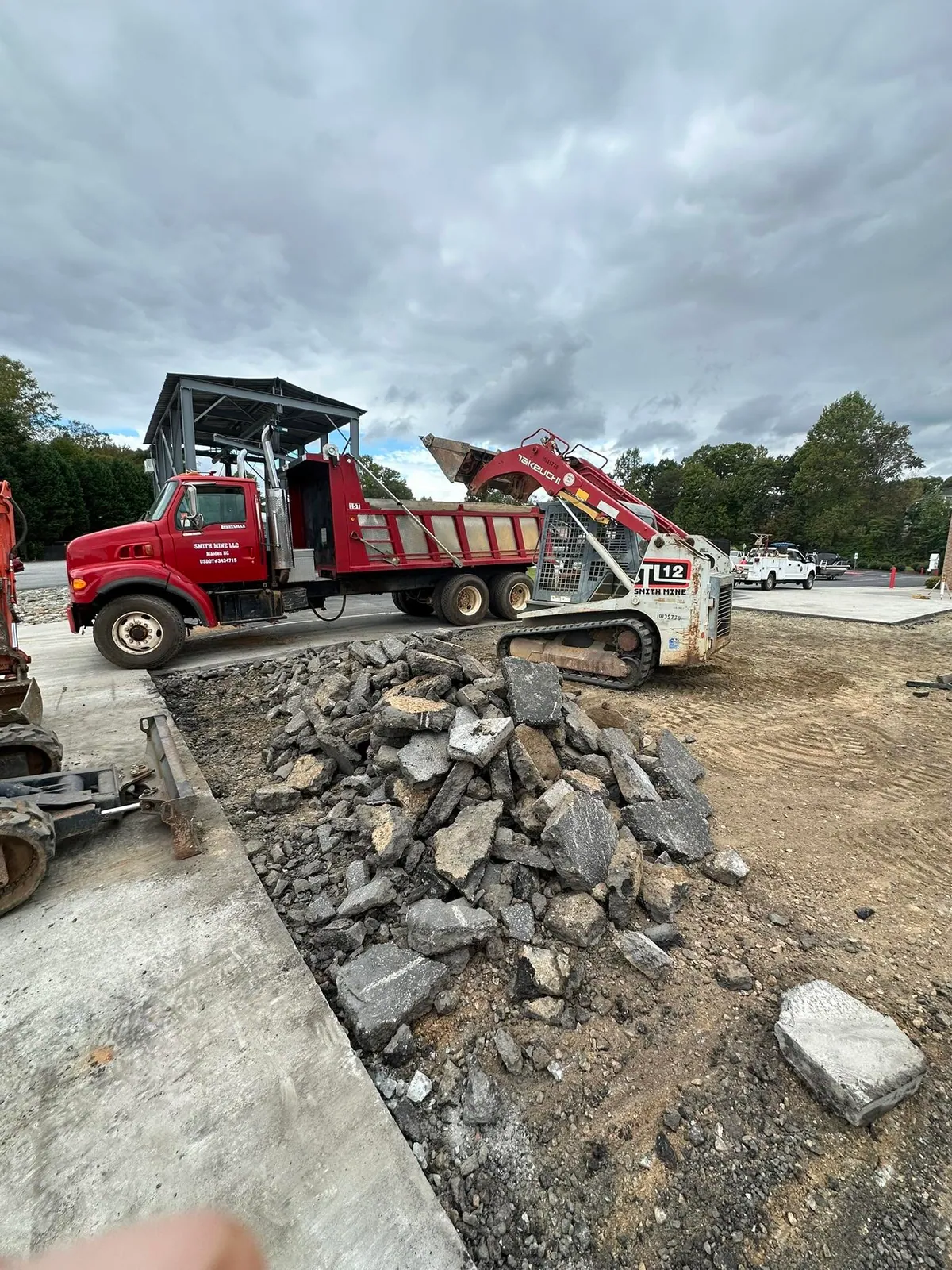 Smith Mine dump truck and Takeuchi TL12 loading broken concrete during commercial slab removal