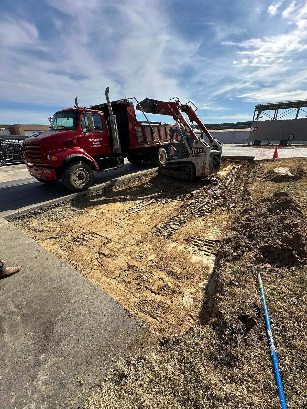 Smith Mine Sterling dump truck and Takeuchi TL12 track loader grading dirt subgrade at marina
